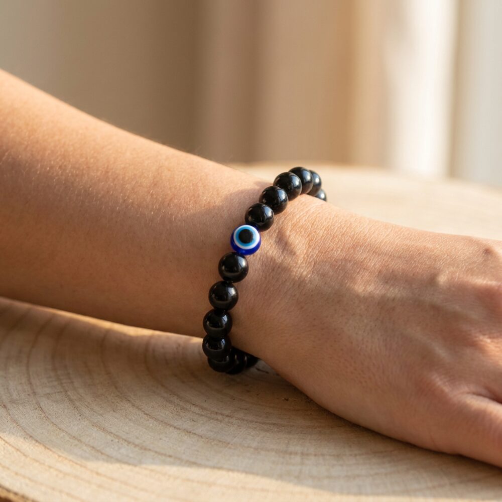 Evil Eye Bracelet with Black Obsidian worn on wrist lifestyle photo on wood surface with natural light