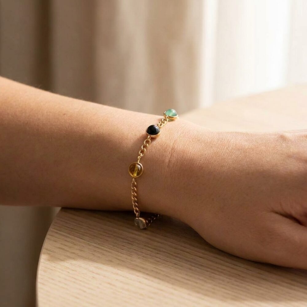 Women's Money Magnet multi-gemstone gold chain bracelet worn on wrist lifestyle photo on wood surface with natural light