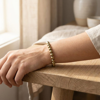 Golden Pyrite Bracelet worn on wrist lifestyle photo on wood surface with natural light