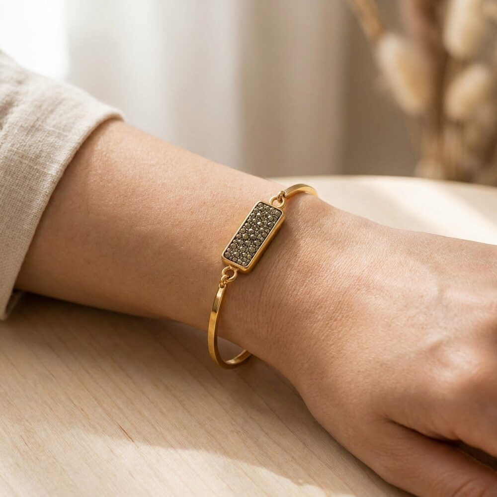 Pyrite Druzy gold-plated wealth bangle for women worn on wrist lifestyle photo on wood surface with natural light