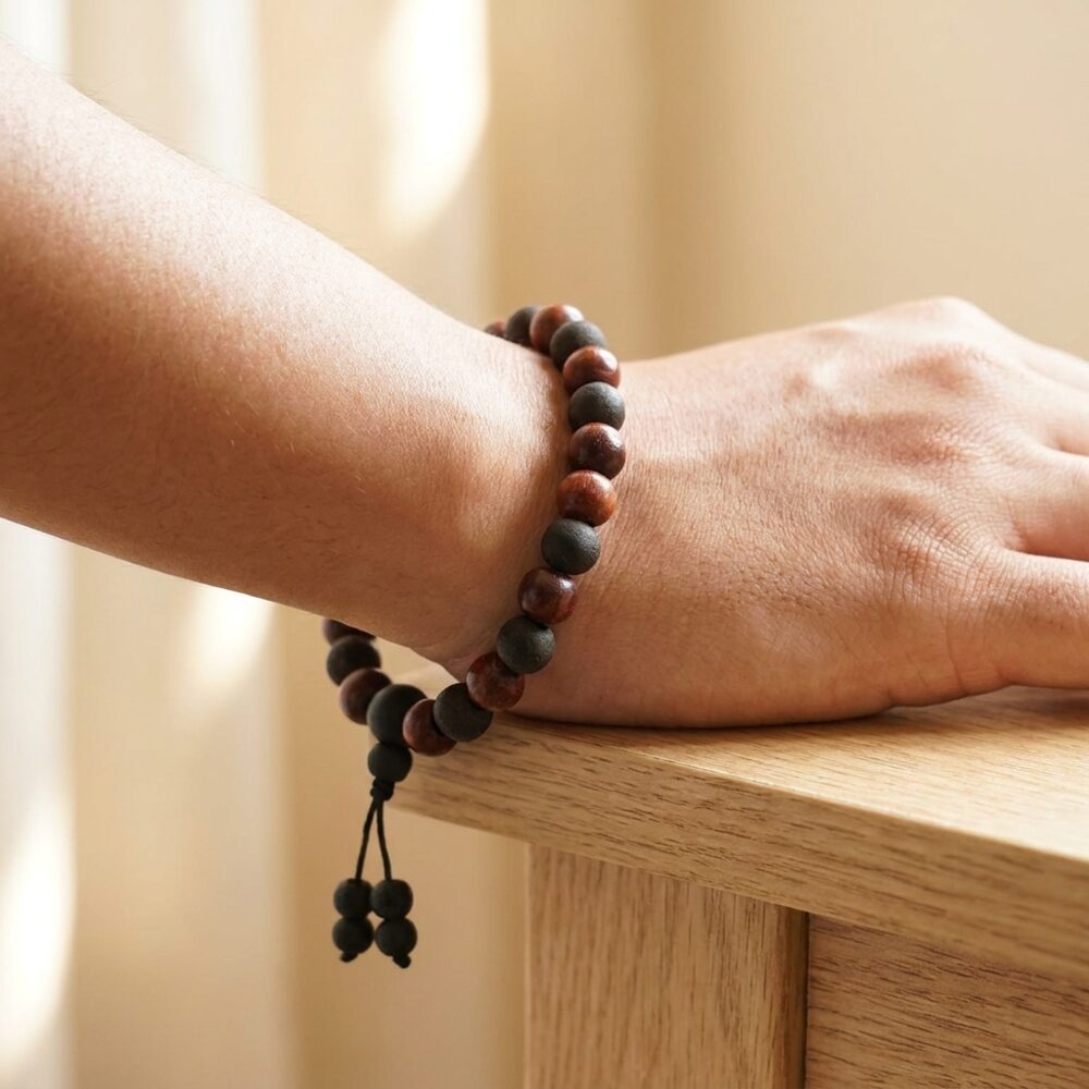 Sandalwood Karungali dual energy bracelet worn on wrist lifestyle photo on wood surface with natural light